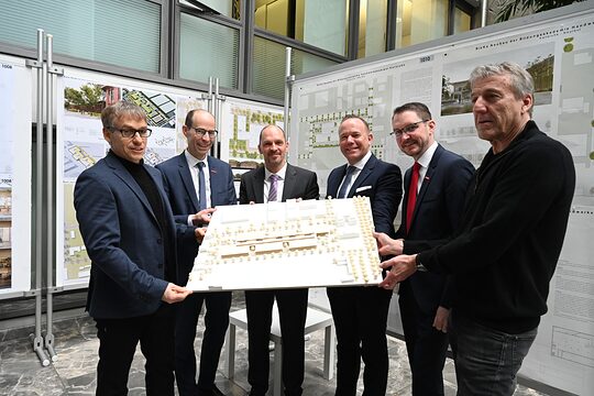 Gruppenbild der Preisträger, die das Siegermodell in den Händen halten.